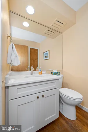 a bathroom with a granite countertop toilet sink and mirror