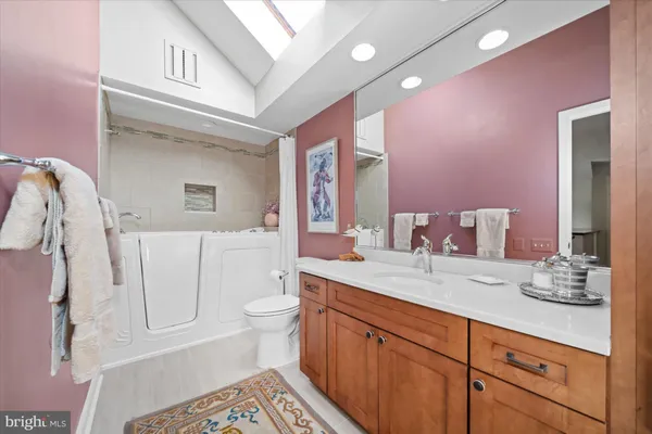a spacious bathroom with a granite countertop sink and a mirror