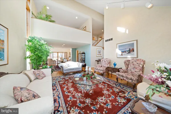 a living room with furniture flowers and a potted plant