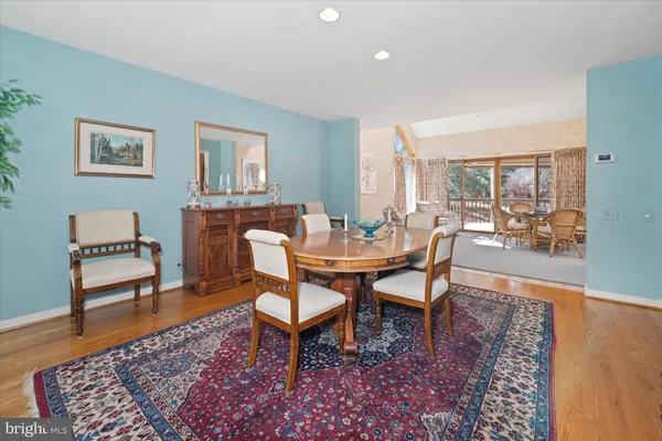 a dining room with wooden floor and a rug