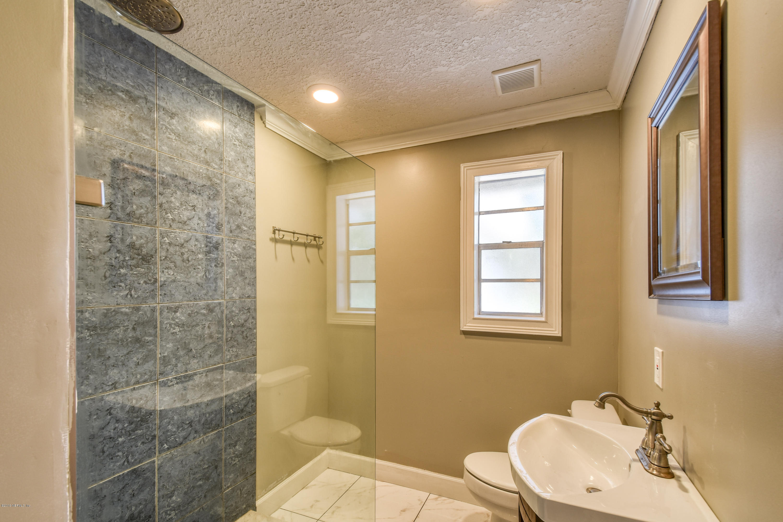 4623 Martingale Road Jacksonville, FL 32210 - Photo 14 of 18 a bathroom with a sink a toilet and shower