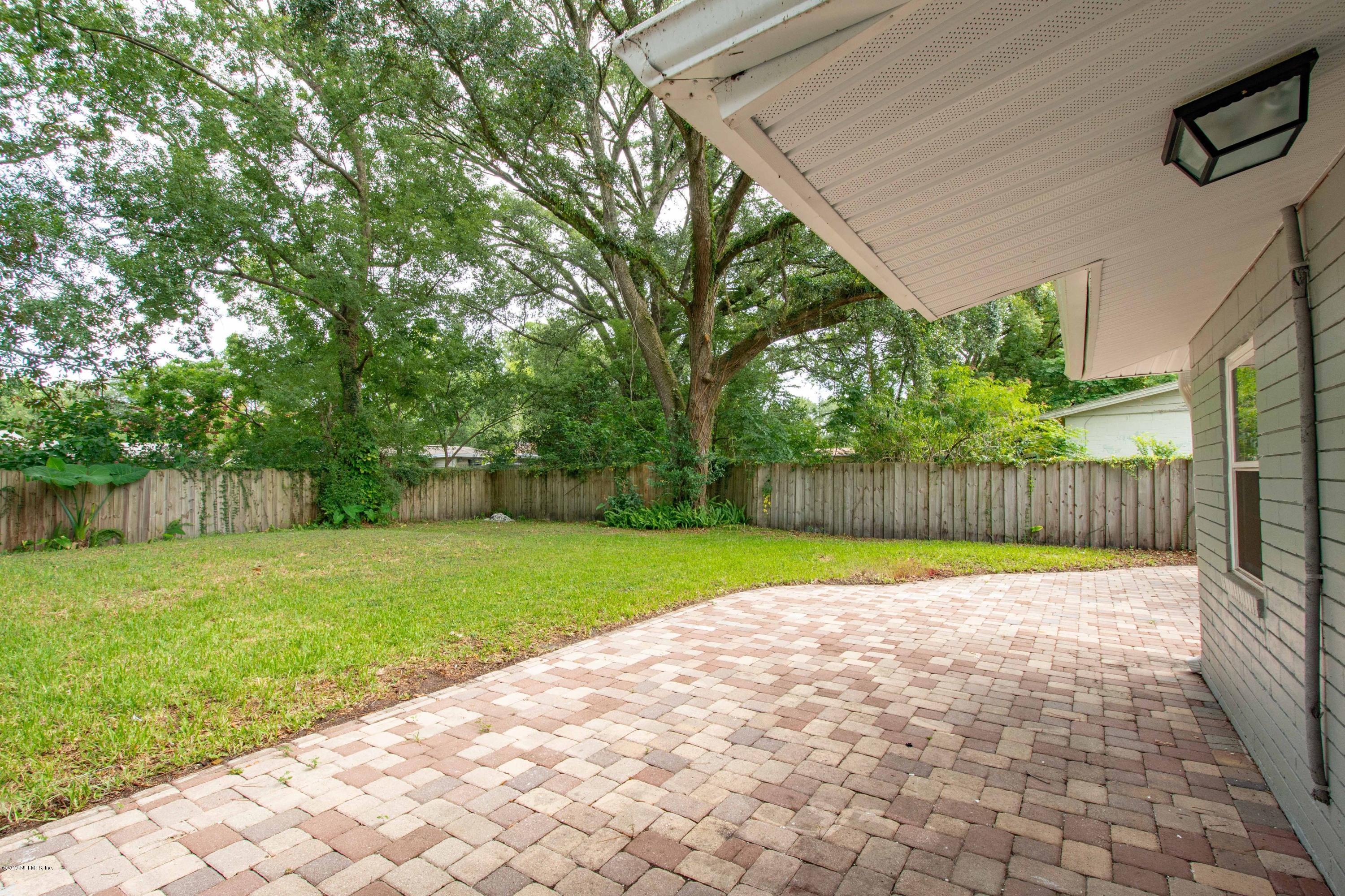 4623 Martingale Road Jacksonville, FL 32210 - Photo 17 of 18 a view of a backyard with large trees and wooden fence