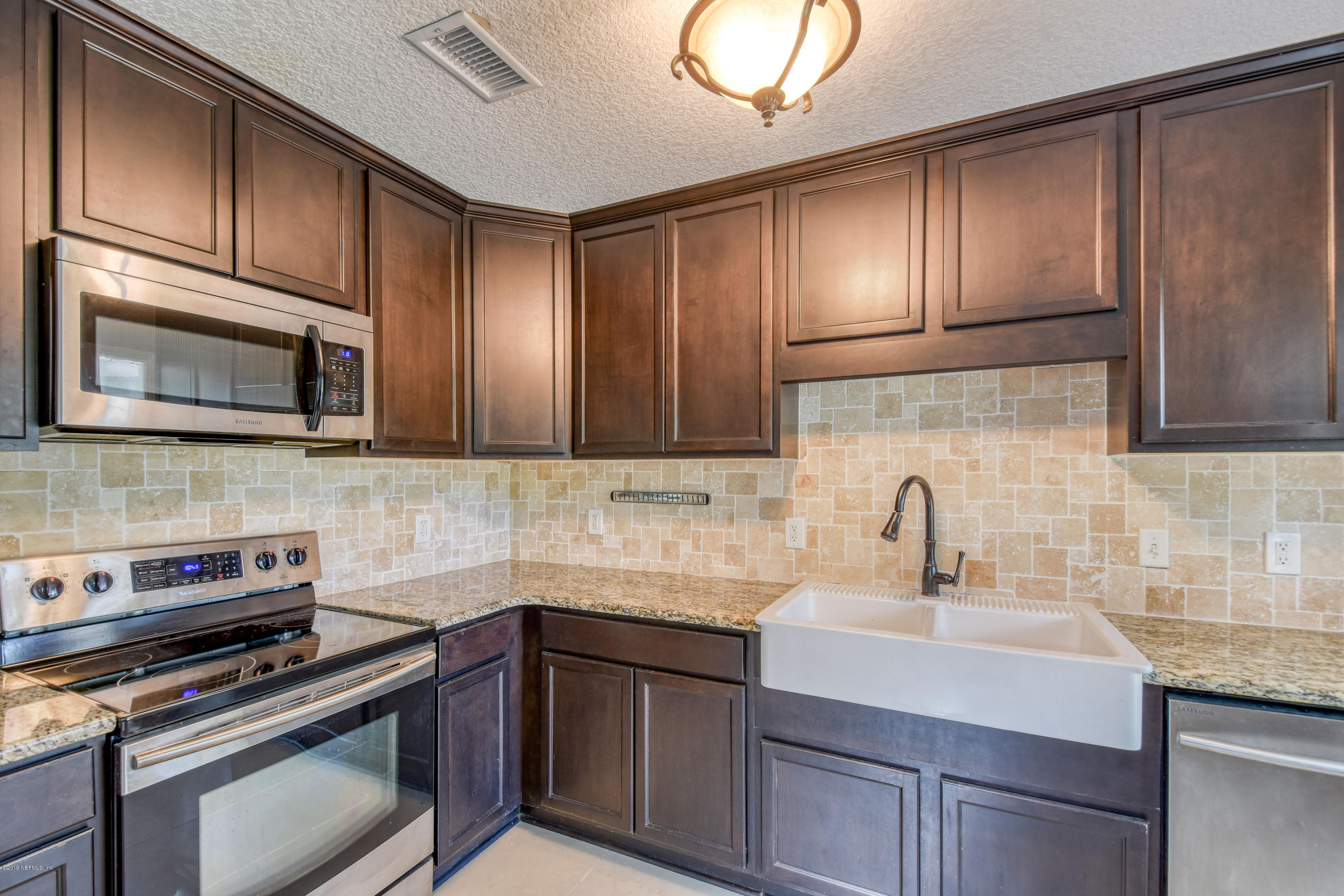 4623 Martingale Road Jacksonville, FL 32210 - Photo 6 of 18 a kitchen with granite countertop wooden cabinets stainless steel appliances and a sink