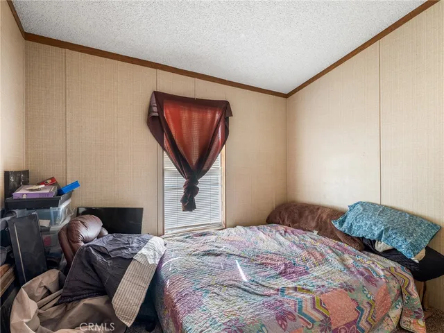 a bedroom with a bed and a painting on the wall