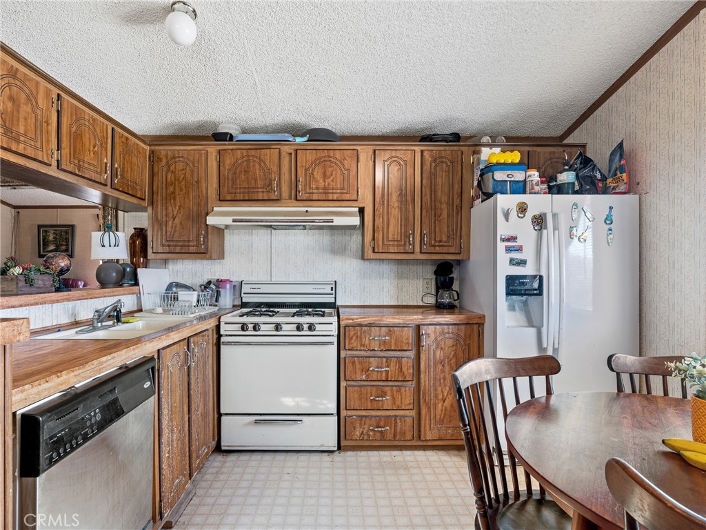 39626 East End Road Lucerne Valley, CA 92356 - Photo 13 of 29 a kitchen with a stove a refrigerator and a dining table