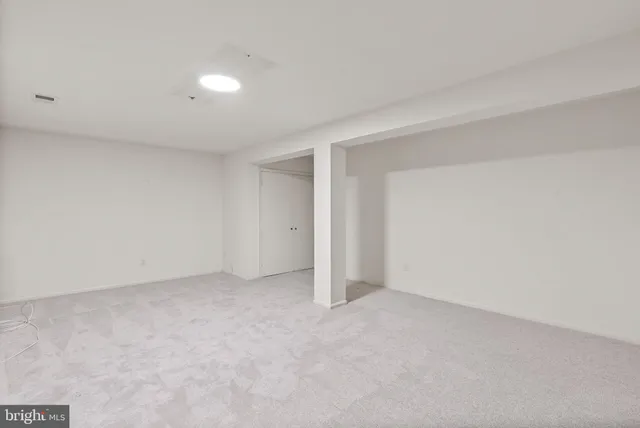 a view of an empty room with a fireplace and a window