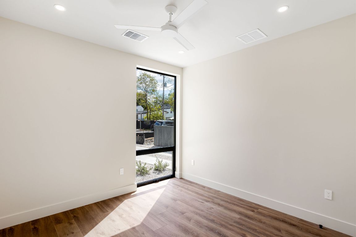 4412 Banister Lane, Unit 1 Austin, TX 78745 - Photo 19 of 40 an empty room with wooden floor and windows