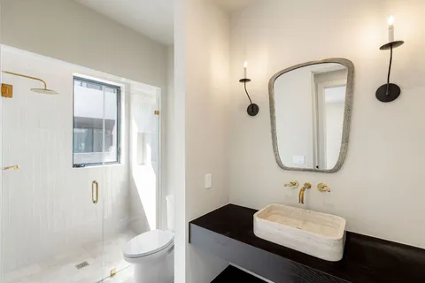 a bathroom with a sink a toilet and shower