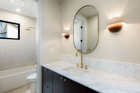 a bathroom with a granite countertop sink and a mirror
