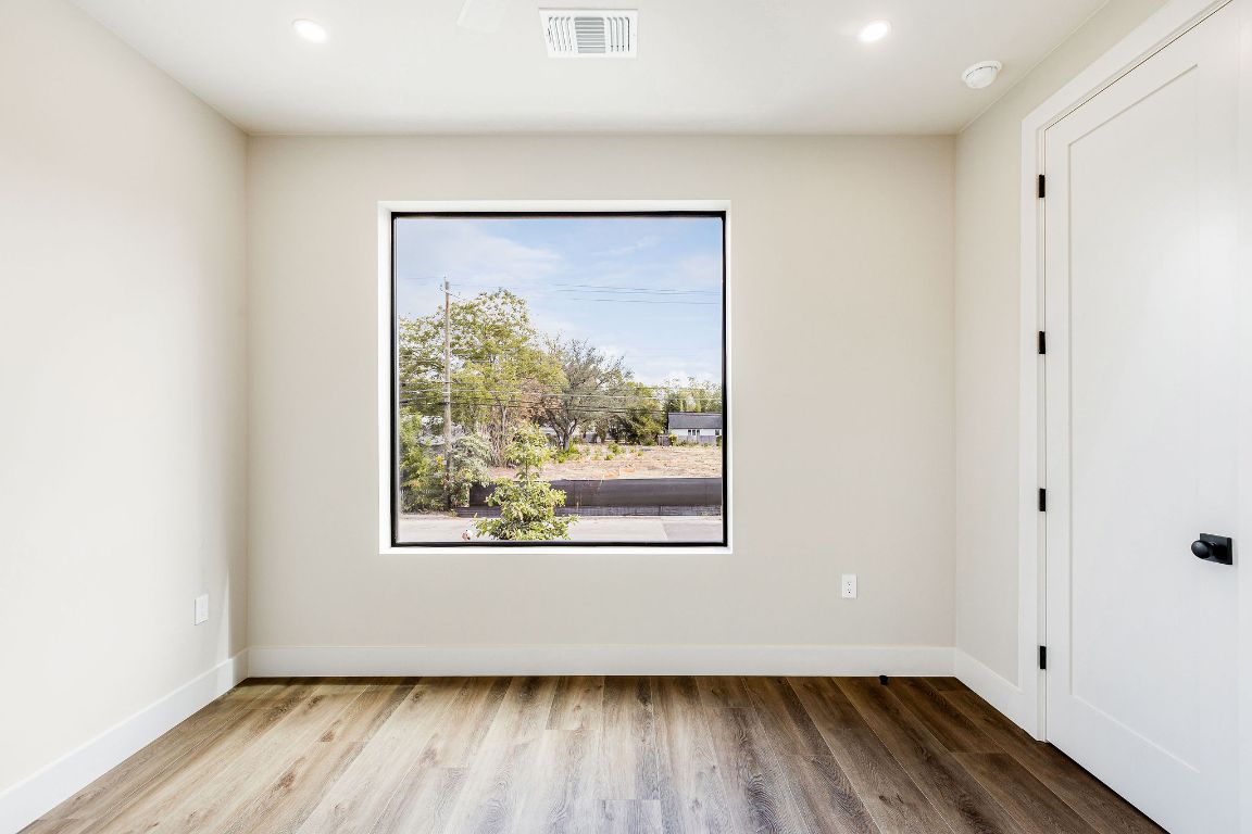 4412 Banister Lane, Unit 1 Austin, TX 78745 - Photo 38 of 40 an empty room with wooden floor and a window
