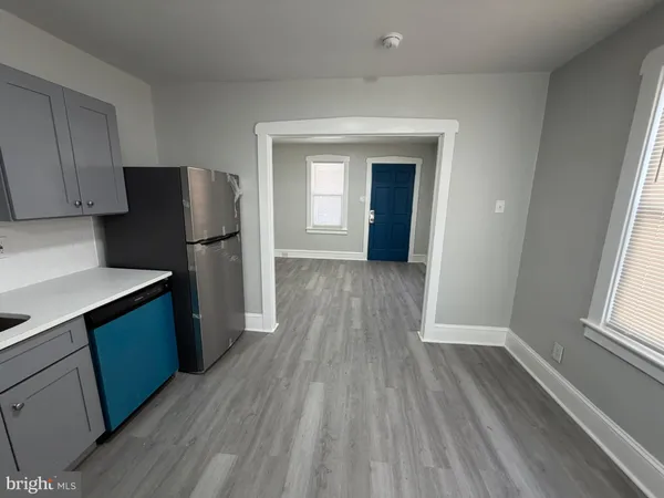 a kitchen with a refrigerator and wooden floor