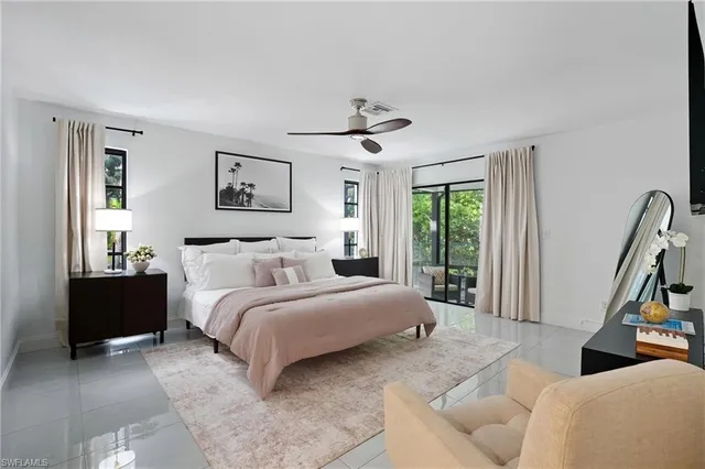 a bedroom with a bed a couch and a large window