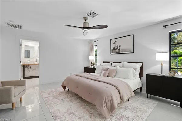 a bedroom with a bed and a lamp on dresser