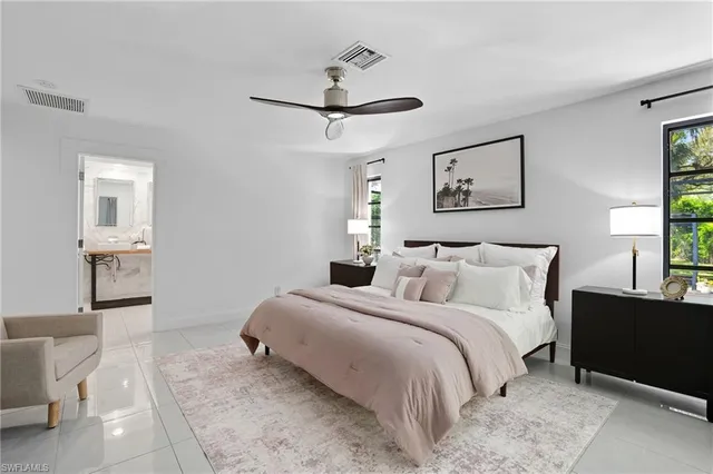 a bedroom with a bed and a lamp on dresser