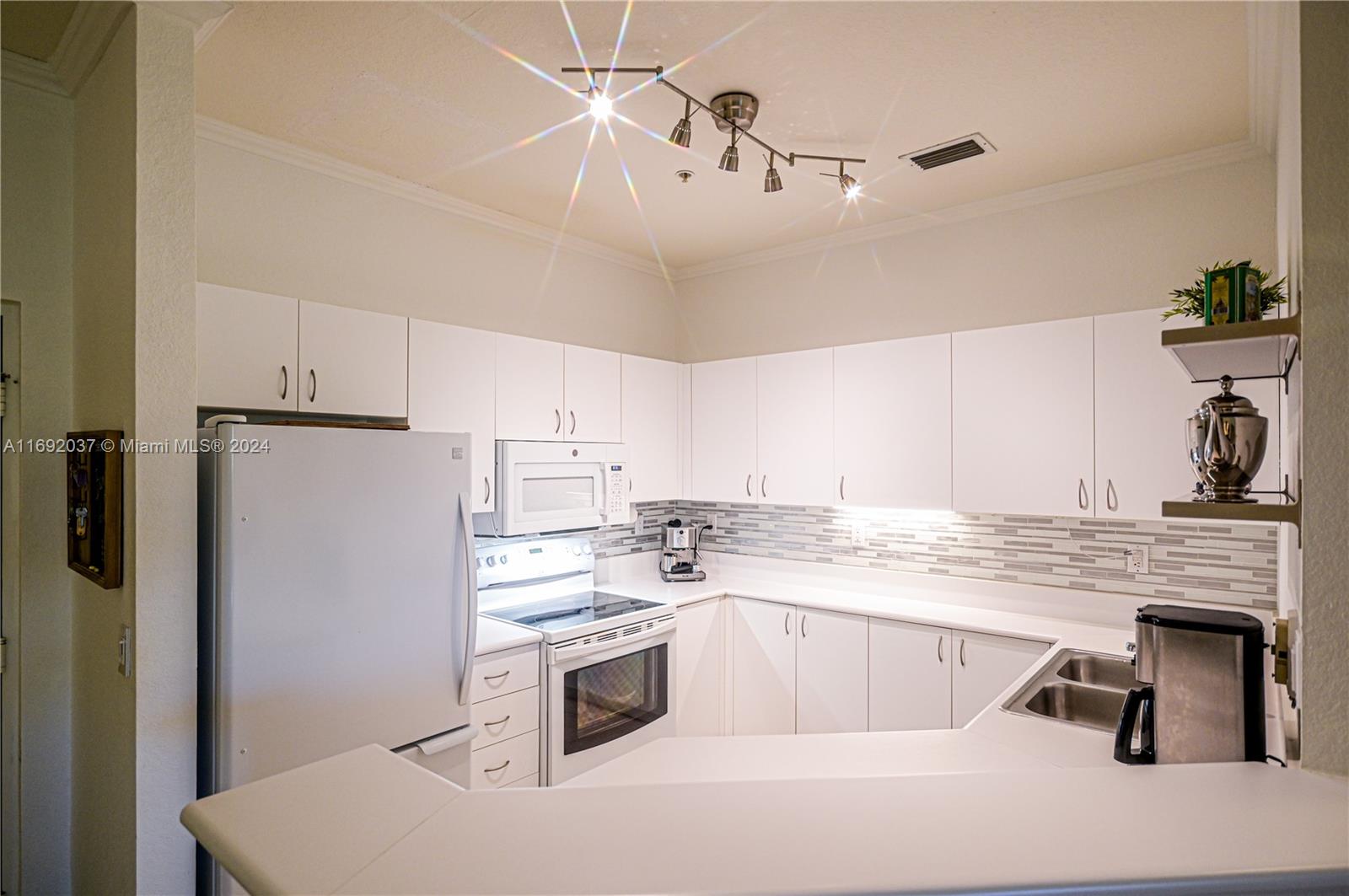 75 Gulfstream Road, Unit 107B Dania Beach, FL 33004 - Photo 14 of 71 a kitchen with kitchen island a stove a sink and a refrigerator
