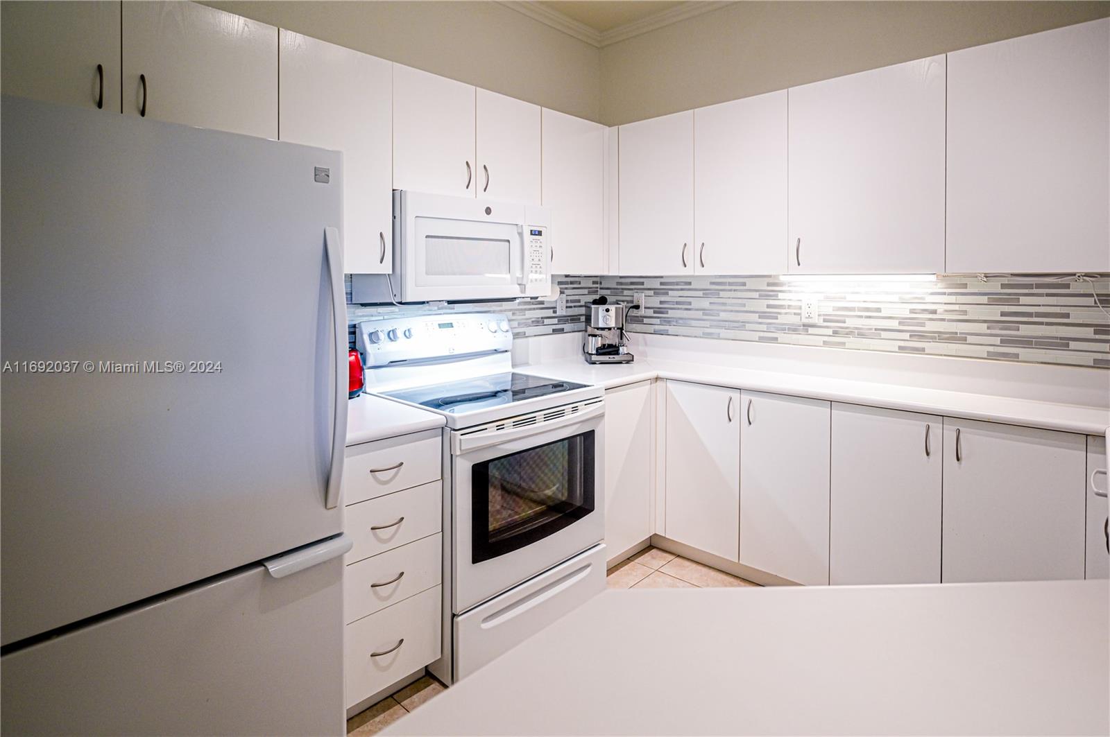 75 Gulfstream Road, Unit 107B Dania Beach, FL 33004 - Photo 17 of 71 a kitchen with white cabinets and white appliances