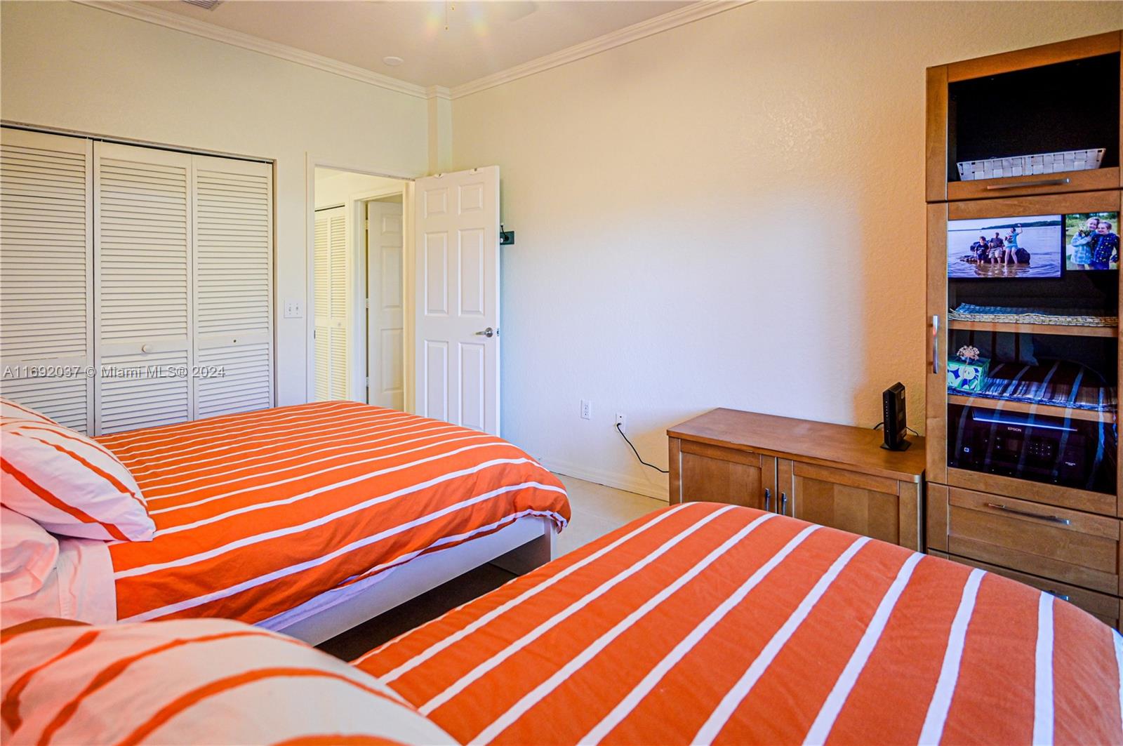 75 Gulfstream Road, Unit 107B Dania Beach, FL 33004 - Photo 38 of 71 a bedroom with a bed and a flat screen tv