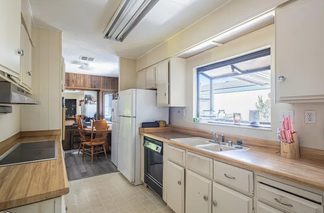 a kitchen that has a lot of cabinets in it and wooden floors