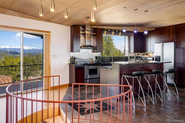 a dining room with wooden floor and large windows