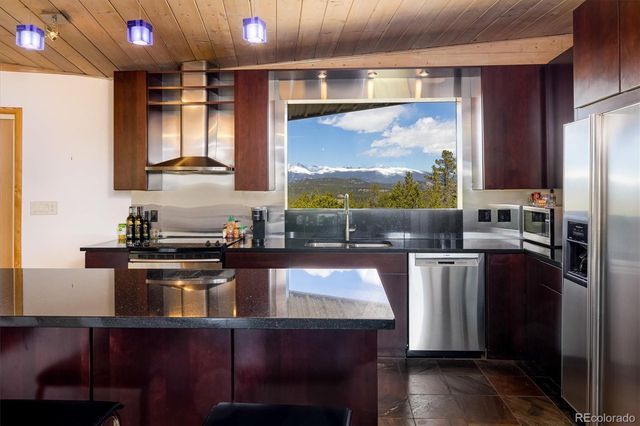 a kitchen with stainless steel appliances granite countertop a stove a sink and a refrigerator