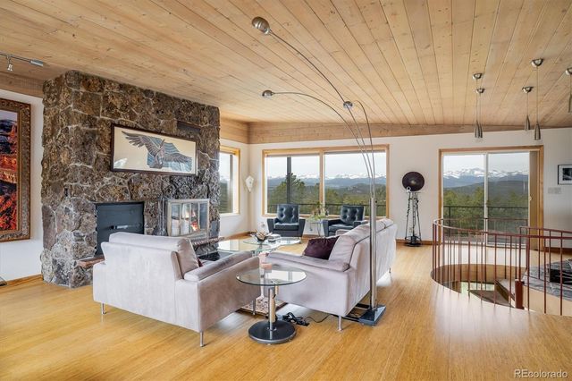 a living room with furniture large window and wooden floor