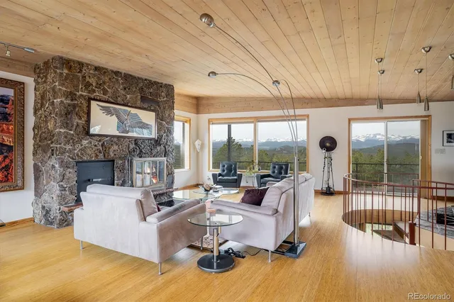 a living room with furniture large window and wooden floor