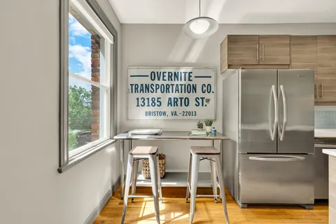 a kitchen with stainless steel appliances granite countertop a refrigerator and a table