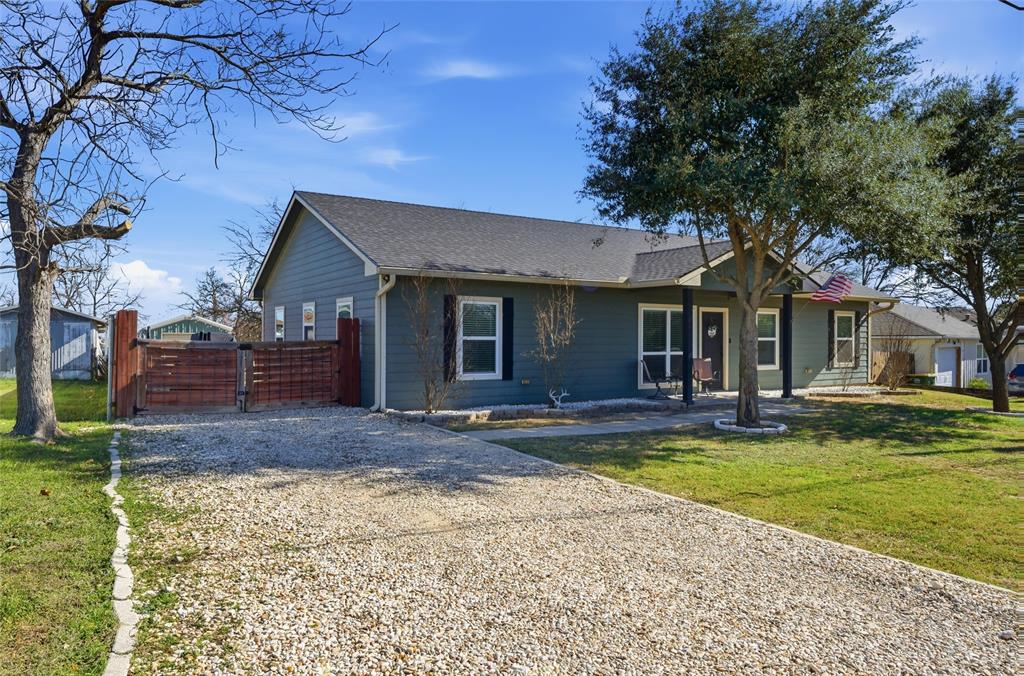 12992 Old Dallas Road West, TX 76691 - Photo 2 of 25 a front view of a house with a garden and trees