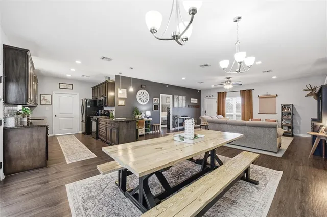 a view of a dining room and livingroom with furniture wooden floor a chandelier