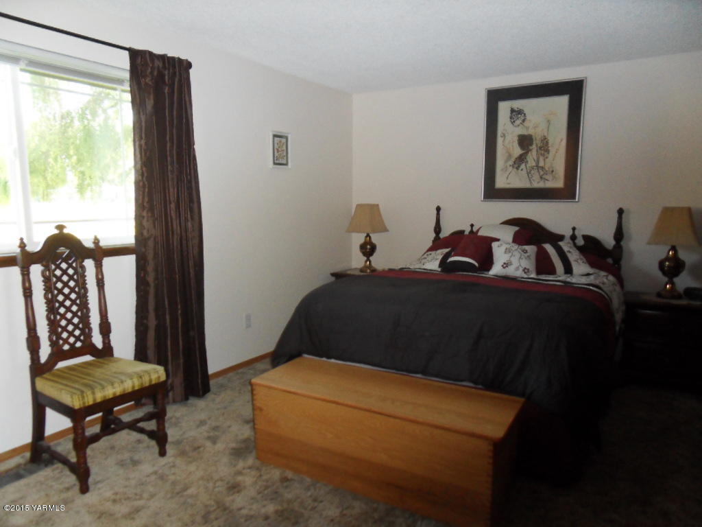 3501 Wiley Road Yakima, WA 98903 - Photo 16 of 31 a bedroom with a bed a chair and a large window