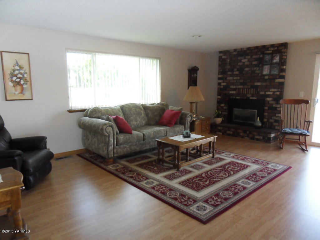 3501 Wiley Road Yakima, WA 98903 - Photo 5 of 31 a living room with furniture a rug and a fireplace