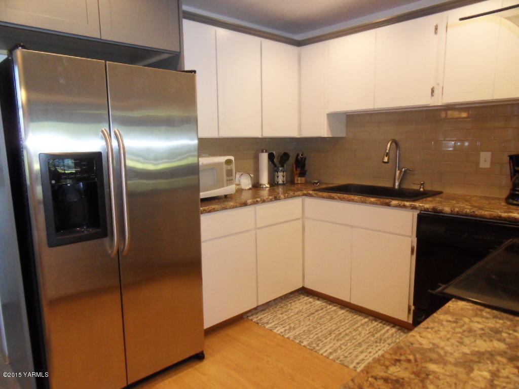 3501 Wiley Road Yakima, WA 98903 - Photo 8 of 31 a kitchen with stainless steel appliances granite countertop a refrigerator a sink and white cabinets