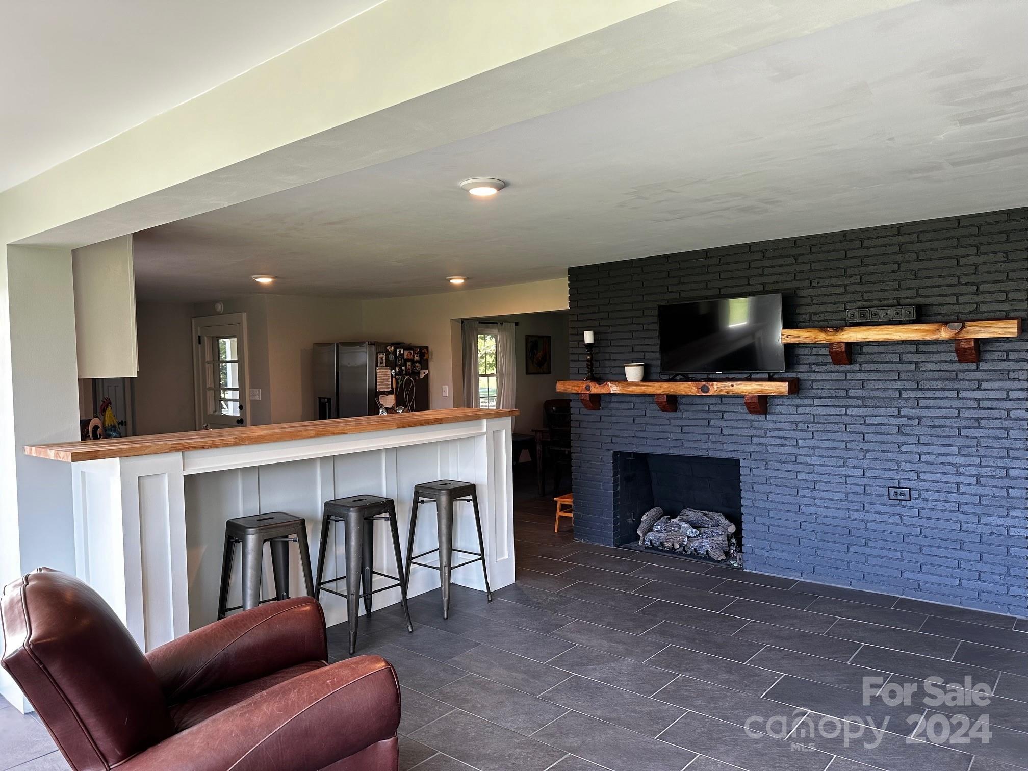 303 Legion Road Hudson, NC 28638 - Photo 26 of 32 a living room with furniture a flat screen tv and a fireplace