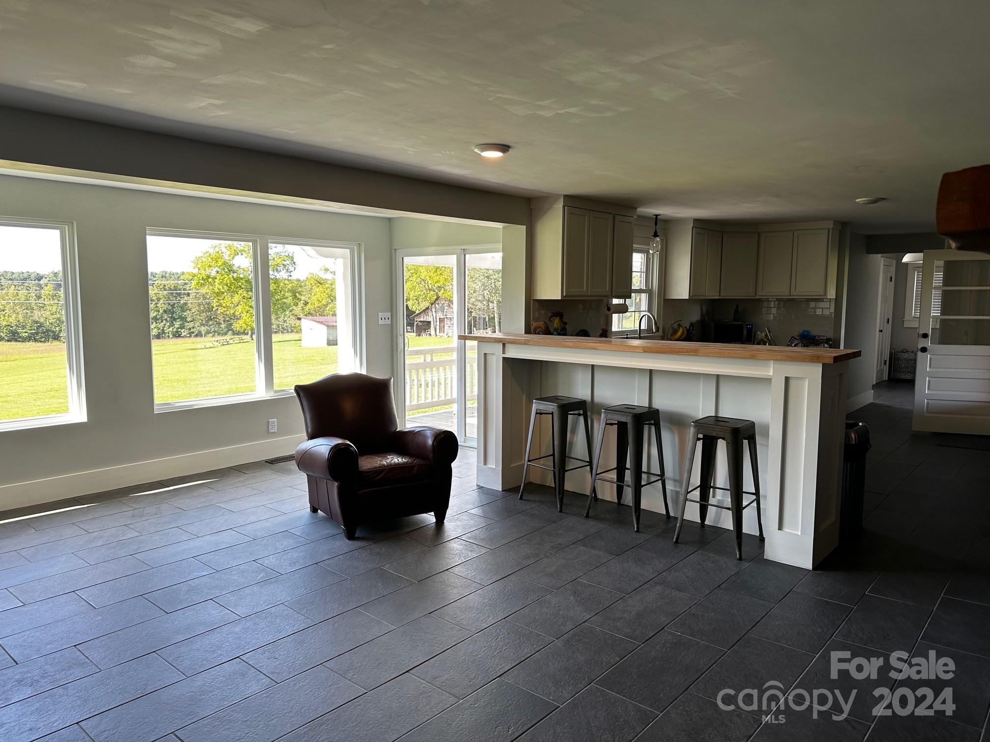 303 Legion Road Hudson, NC 28638 - Photo 6 of 32 a living room with furniture a large window and a fireplace