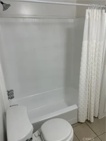 a white toilet and tub sitting next to a shower