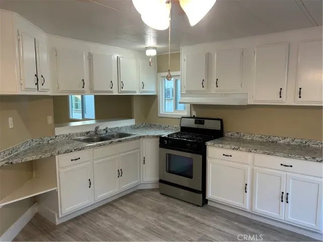 a kitchen with granite countertop white cabinets and white appliances