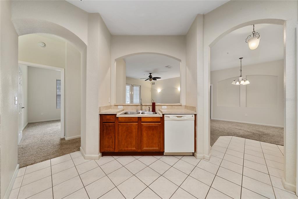 3001 Greystone Loop, Unit 103 Kissimmee, FL 34741 - Photo 12 of 31 a view of a kitchen with kitchen island a sink a stove and a refrigerator
