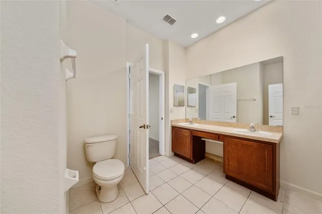 a spacious bathroom with a granite countertop toilet sink and mirror