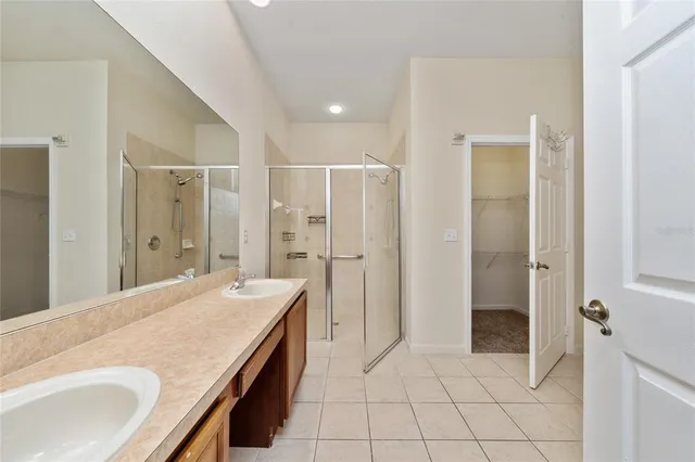 a spacious bathroom with a granite countertop sink a mirror and a shower