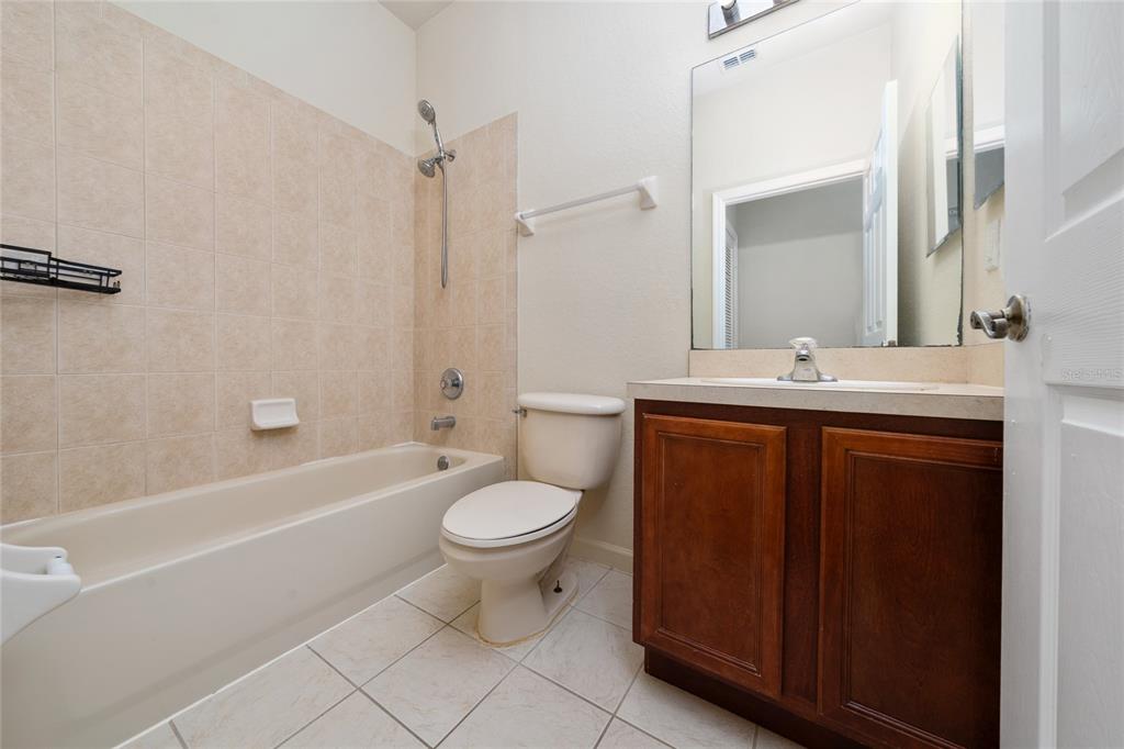 3001 Greystone Loop, Unit 103 Kissimmee, FL 34741 - Photo 21 of 31 a bathroom with a sink a toilet and shower