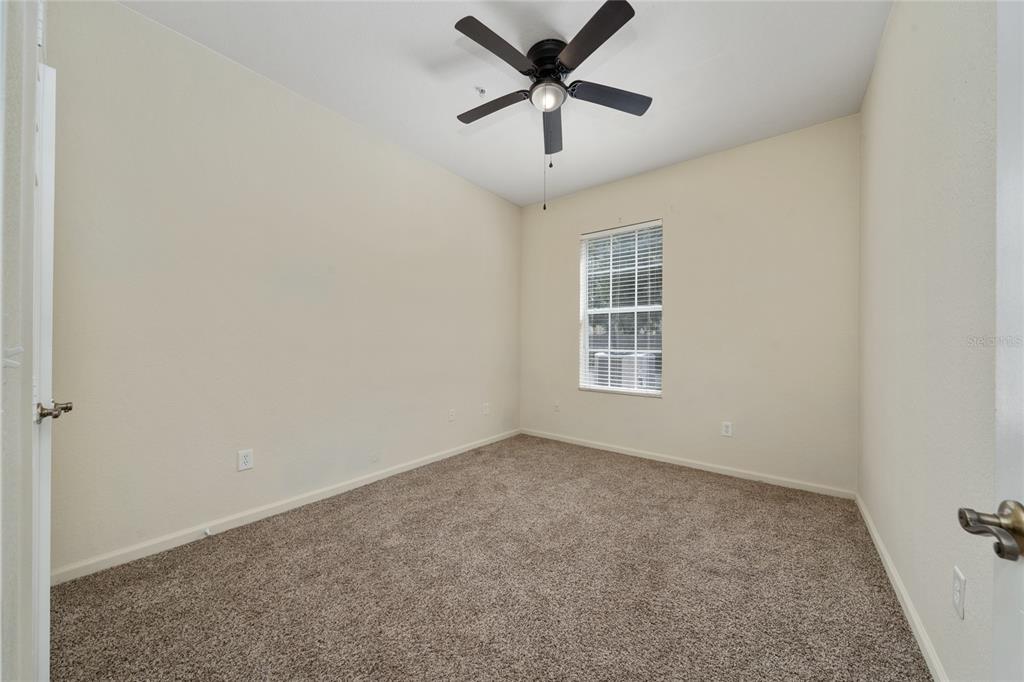 3001 Greystone Loop, Unit 103 Kissimmee, FL 34741 - Photo 22 of 31 an empty room with a window and a ceiling fan