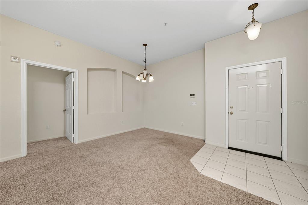 3001 Greystone Loop, Unit 103 Kissimmee, FL 34741 - Photo 7 of 31 an empty room with chandelier fan and windows
