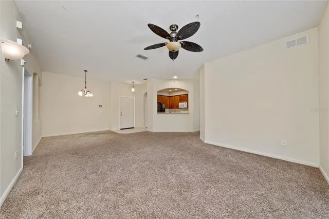 en empty room with a ceiling fan and a window