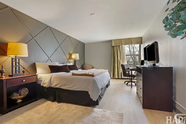 a bedroom with bed tv and window