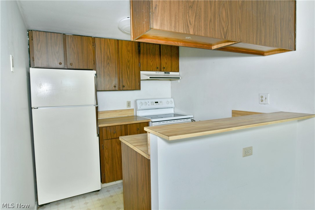 3020 North River Road Northeast, Unit G2 Warren, OH 44483 - Photo 11 of 29 Kitchen featuring kitchen peninsula, white appliances, and light tile floors