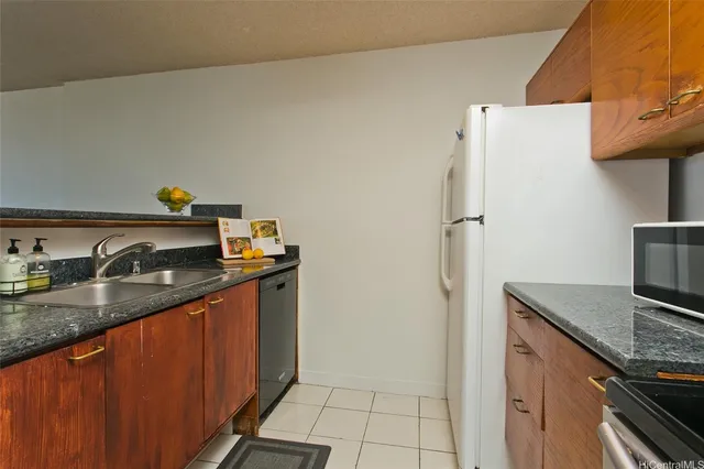a kitchen with stainless steel appliances granite countertop a sink and a refrigerator