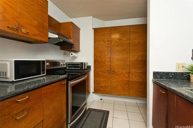 a kitchen with stainless steel appliances granite countertop a stove and a microwave