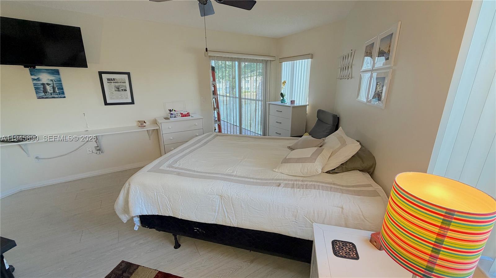 9539 Weldon Circle, Unit F207 Tamarac, FL 33321 - Photo 13 of 22 a bedroom with a bed and wooden floor