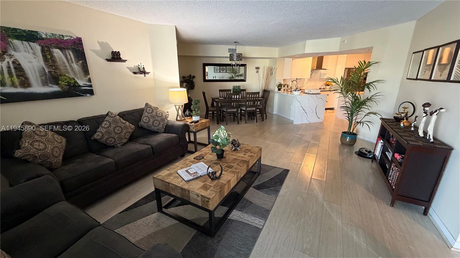 9539 Weldon Circle, Unit F207 Tamarac, FL 33321 - Photo 21 of 22 a living room with furniture and a flat screen tv