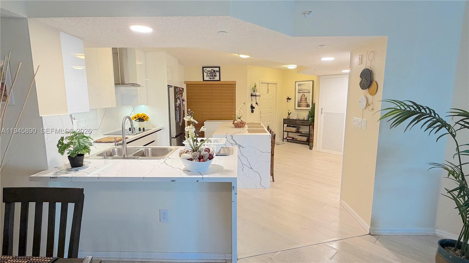 9539 Weldon Circle, Unit F207 Tamarac, FL 33321 - Photo 4 of 22 a kitchen with kitchen island granite countertop a sink counter top space and living room view
